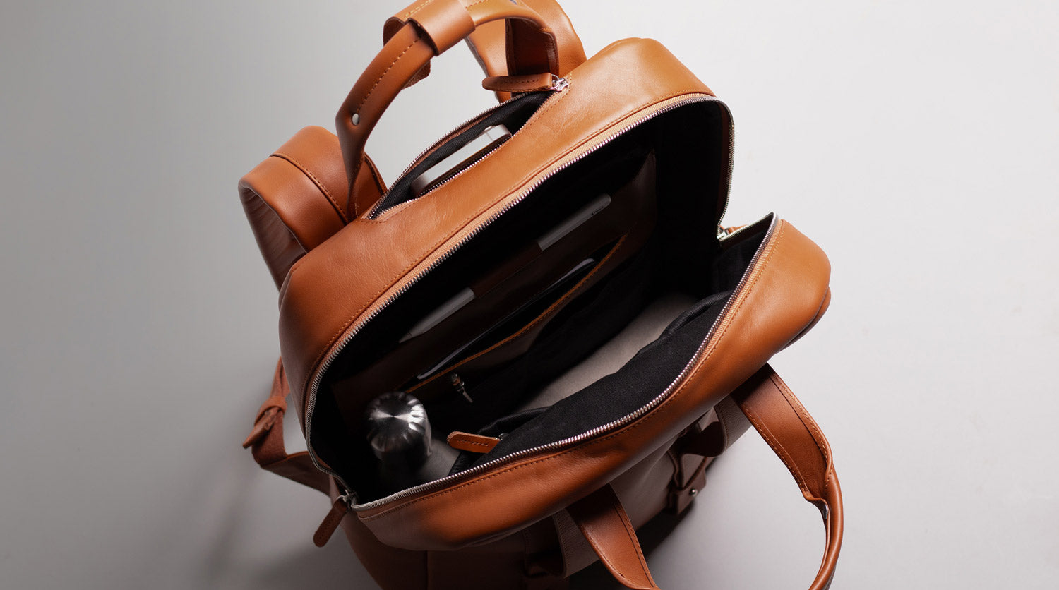 Open City leather backpack with inner padded pockets for laptops and tablets.