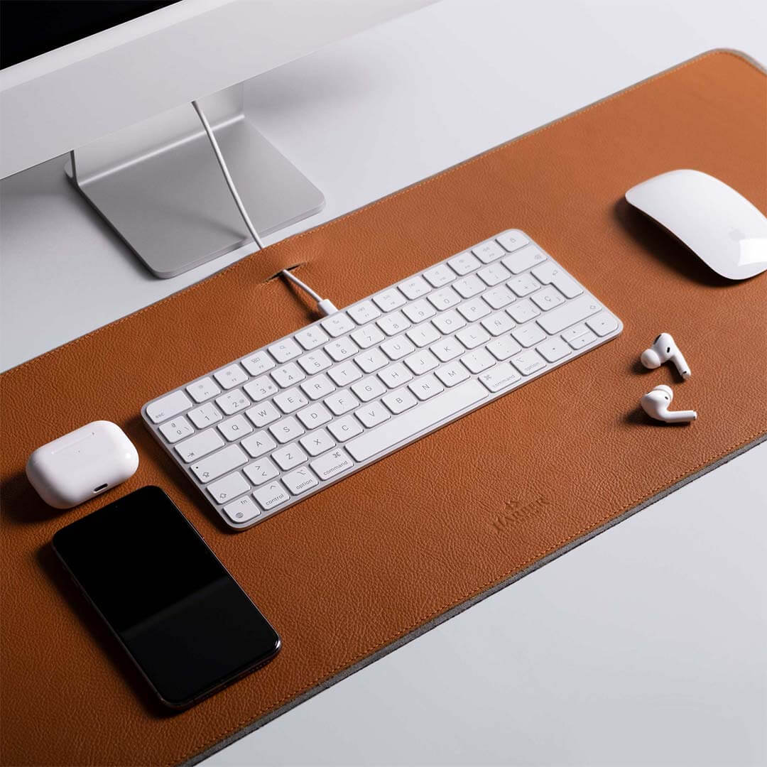 Leather desk mat with a keyboard, mouse and other stuff on it