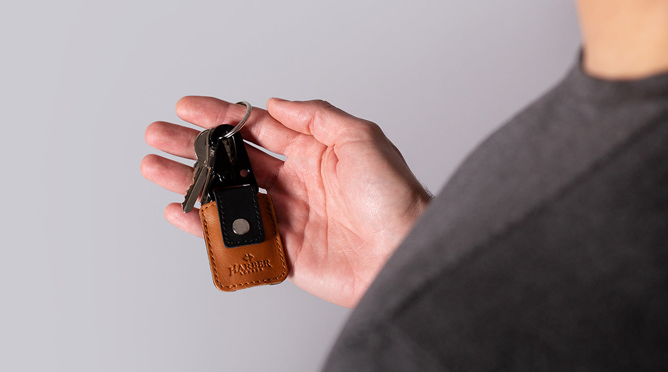 Persona con una funda AirTag de cuero